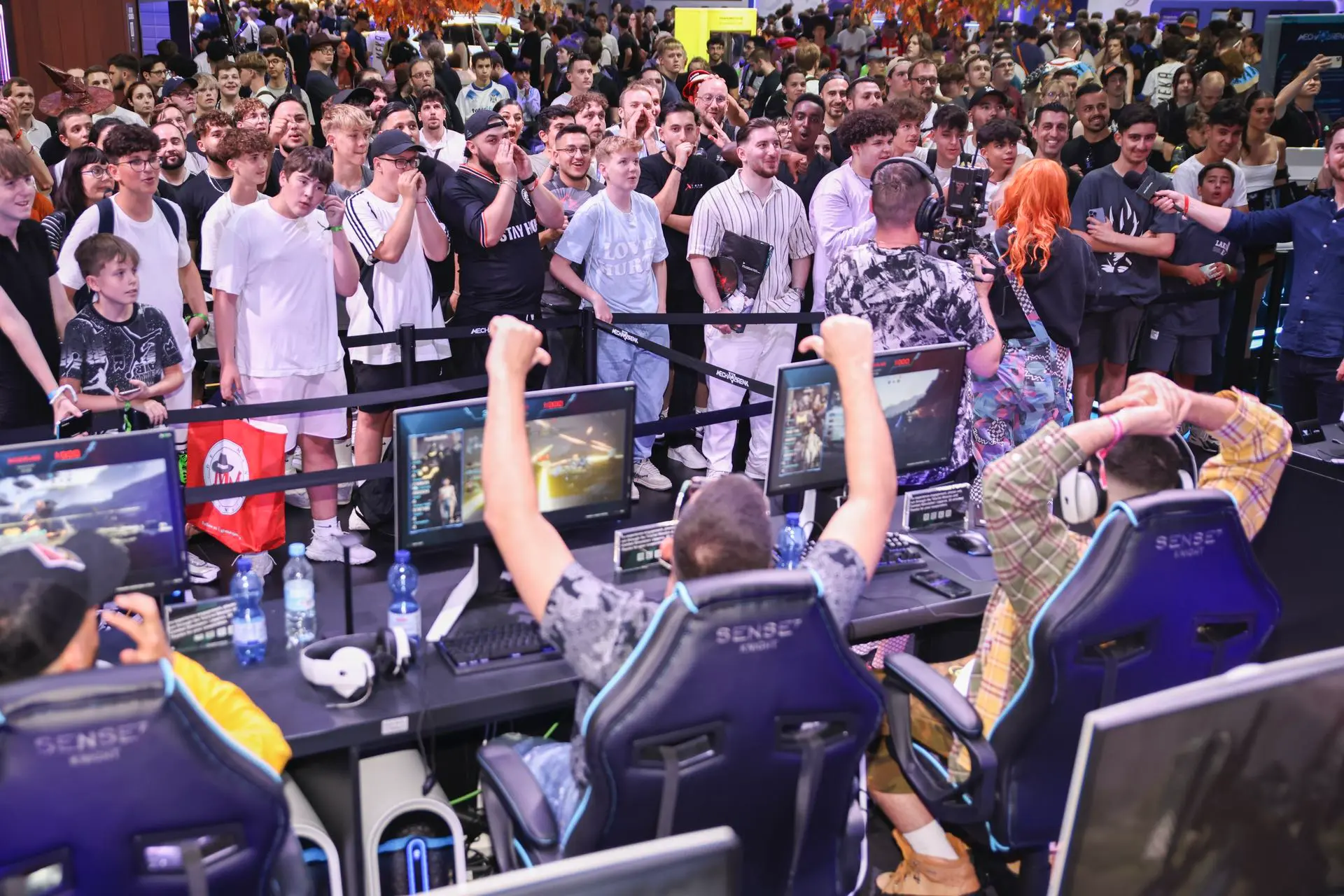 Publikum verfolgt ein Gaming-Match am Messestand auf der gamescom Köln